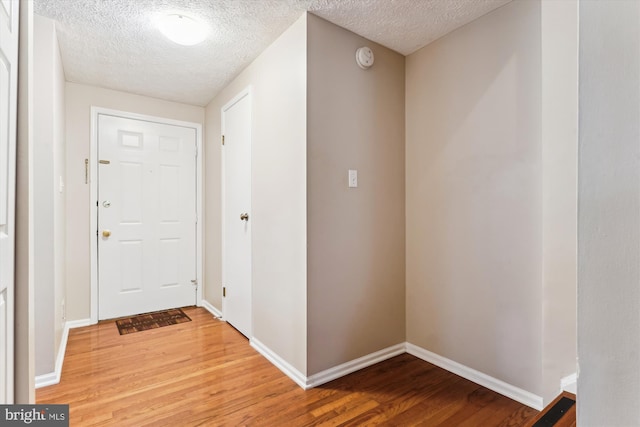 9175 Forest Lawn Ct, Springfield, VA 22152 - foyer entrance with light wood-style flooring, a textured ceiling, and baseboards