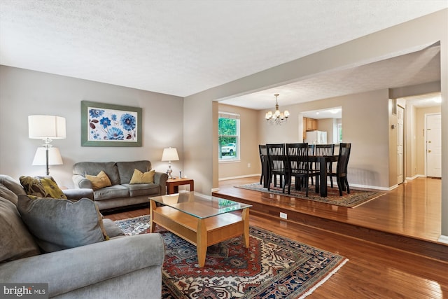 9175 Forest Lawn Ct, Springfield, VA 22152 - living area featuring a chandelier, wood finished floors, baseboards, and a textured ceiling