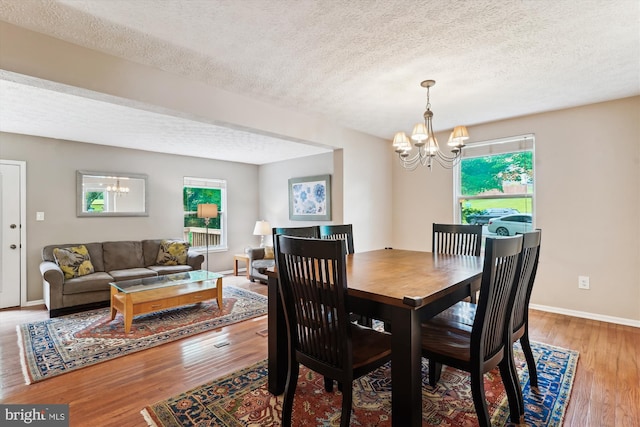 9175 Forest Lawn Ct, Springfield, VA 22152 - dining area with a chandelier, wood finished floors, a textured ceiling, and baseboards