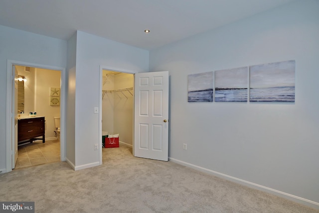 5909 Founders Hill Dr Unit 101, Alexandria, VA 22310 - unfurnished bedroom featuring light carpet, a spacious closet, baseboards, a closet, and connected bathroom