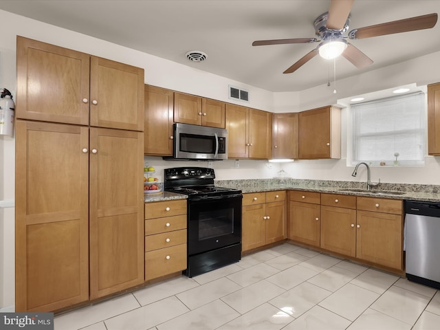 3807 24th Ave, Temple Hills, MD 20748 - kitchen featuring stainless steel appliances, a sink, a ceiling fan, light stone counters, and brown cabinetry