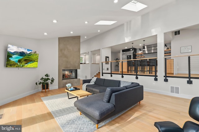 2201 Burgee Ct, Reston, VA 20191 - living room featuring a skylight, wood finished floors, a multi sided fireplace, stairway, and baseboards