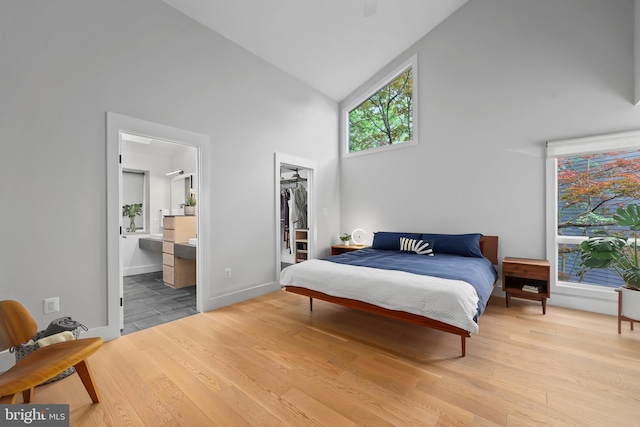 2201 Burgee Ct, Reston, VA 20191 - bedroom with high vaulted ceiling, wood finished floors, a walk in closet, a closet, and ensuite bathroom
