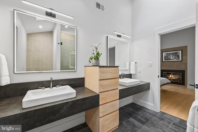 2201 Burgee Ct, Reston, VA 20191 - bathroom featuring connected bathroom, two vanities, and a glass covered fireplace