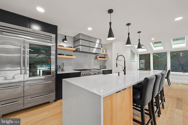 2201 Burgee Ct, Reston, VA 20191 - kitchen featuring stainless steel built in refrigerator, wall chimney exhaust hood, a skylight, light wood-type flooring, and recessed lighting