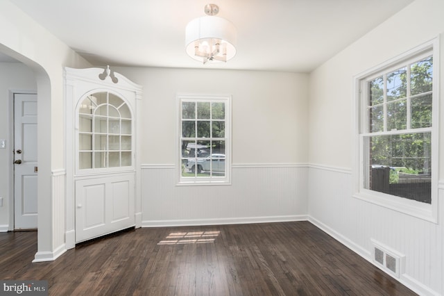 5312 Baltimore Ave, Chevy Chase, MD 20815 - unfurnished dining area with wainscoting, dark wood finished floors, arched walkways, and a chandelier