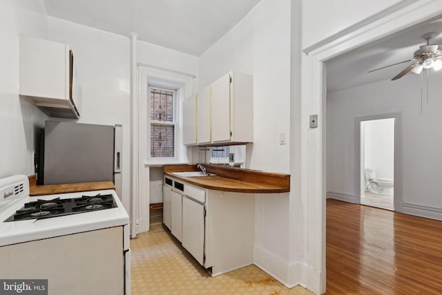 1514 17th St NW Unit 114, Washington, DC 20036 - kitchen featuring white gas stove, freestanding refrigerator, a ceiling fan, white cabinets, and light wood-style flooring