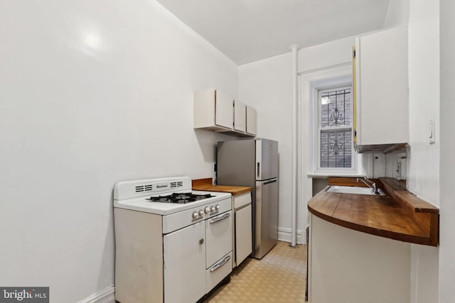 1514 17th St NW Unit 114, Washington, DC 20036 - kitchen featuring gas range gas stove, freestanding refrigerator, wood counters, and light flooring