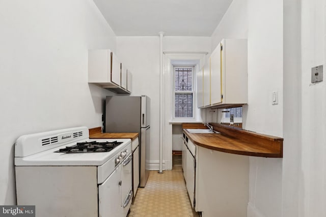 1514 17th St NW Unit 114, Washington, DC 20036 - kitchen with white gas range, light flooring, butcher block countertops, white cabinetry, and freestanding refrigerator
