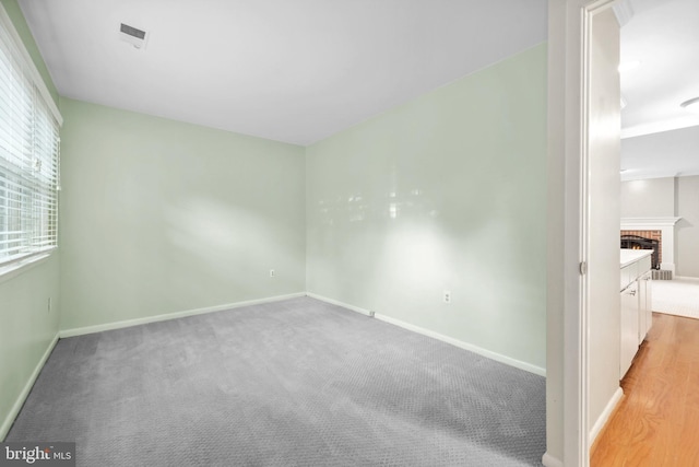 2893 Sutton Oaks Ln, Vienna, VA 22181 - empty room with baseboards, light colored carpet, and a brick fireplace