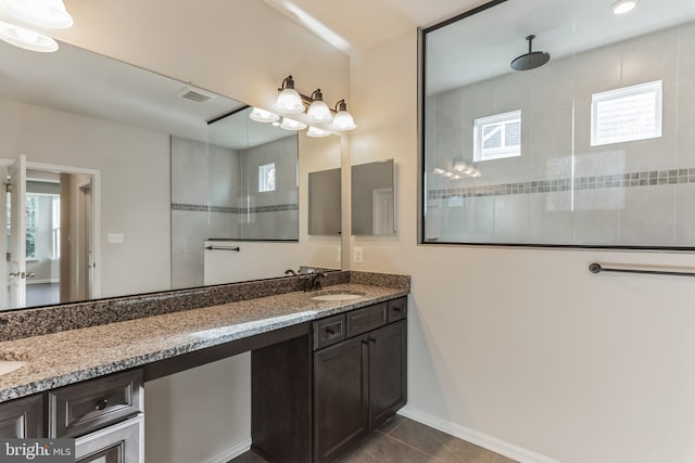 33841 Joel Ln, Lewes, DE 19958 - bathroom with double vanity, tiled shower, tile patterned floors, and baseboards