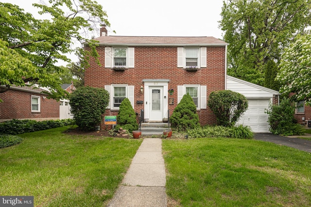 617 March St, Reading, PA 19607 - colonial home featuring a front lawn, a chimney, asphalt driveway, and brick siding