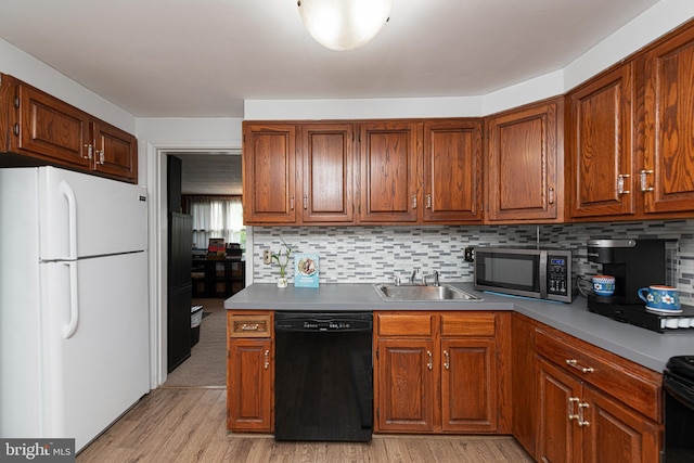 617 March St, Reading, PA 19607 - kitchen with freestanding refrigerator, black dishwasher, stainless steel microwave, a sink, and light wood-type flooring