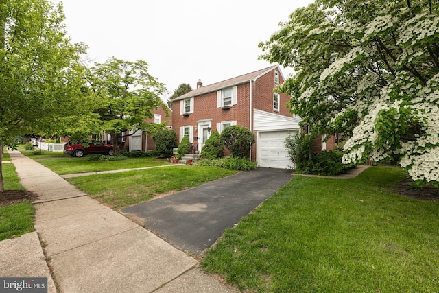 617 March St, Reading, PA 19607 - colonial-style house featuring driveway, brick siding, an attached garage, a front yard, and a chimney