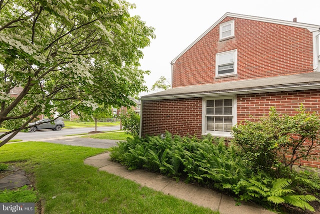 617 March St, Reading, PA 19607 - view of side of property with brick siding and a yard