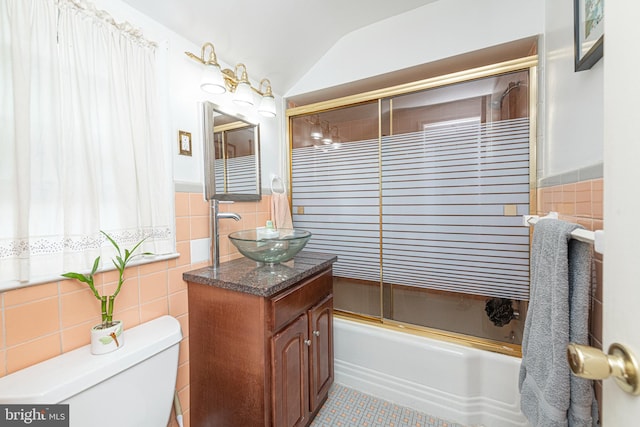 617 March St, Reading, PA 19607 - bathroom with tile walls, vanity, toilet, enclosed tub / shower combo, and lofted ceiling