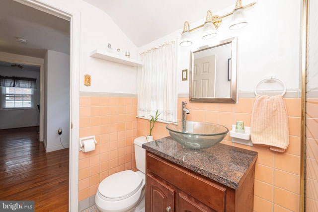 617 March St, Reading, PA 19607 - bathroom featuring lofted ceiling, vanity, tile walls, toilet, and wood finished floors