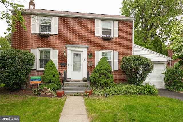 617 March St, Reading, PA 19607 - colonial home with a chimney, a front lawn, brick siding, and asphalt driveway