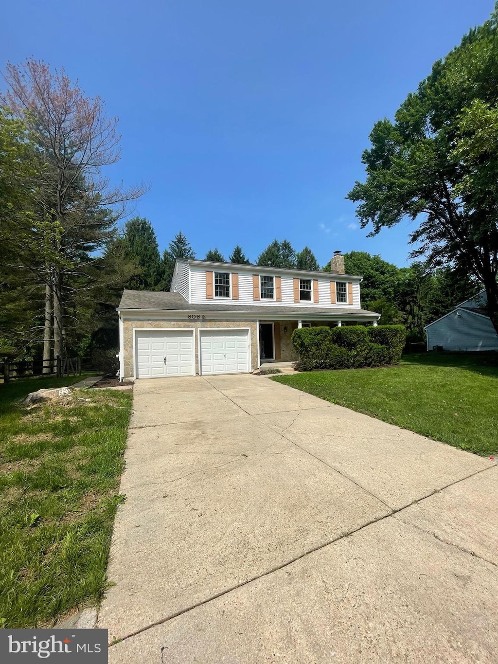 6066 Camelback Ln, Columbia, MD 21045 - view of front of house featuring concrete driveway, a front yard, a chimney, and a garage