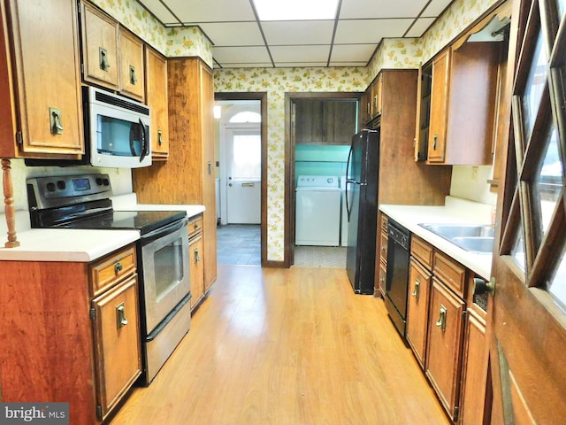 1216 23rd Ave, Altoona, PA 16601 - kitchen featuring black appliances, washer / dryer, wallpapered walls, a paneled ceiling, and a sink