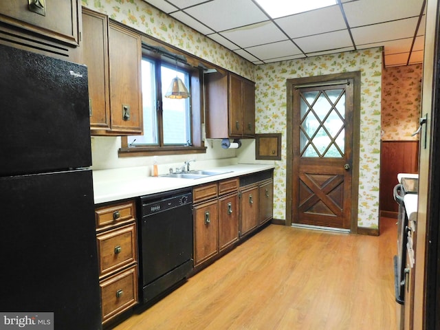1216 23rd Ave, Altoona, PA 16601 - kitchen with black appliances, wallpapered walls, a sink, light wood finished floors, and light countertops
