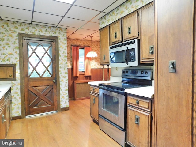 1216 23rd Ave, Altoona, PA 16601 - kitchen featuring appliances with stainless steel finishes, wallpapered walls, light wood-type flooring, a drop ceiling, and baseboards