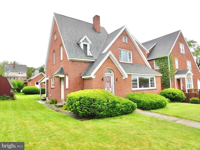 1216 23rd Ave, Altoona, PA 16601 - view of front of home with roof with shingles, a front lawn, brick siding, and a chimney