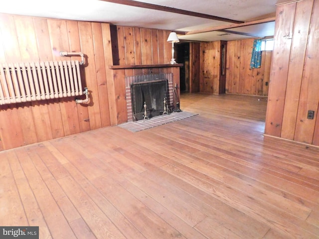 1216 23rd Ave, Altoona, PA 16601 - unfurnished living room with radiator, wood-type flooring, wood walls, and a fireplace