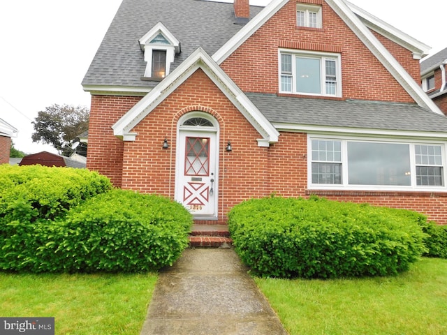 1216 23rd Ave, Altoona, PA 16601 - view of front of property featuring brick siding, roof with shingles, and a chimney