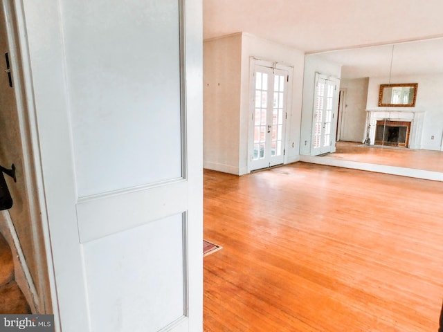 1216 23rd Ave, Altoona, PA 16601 - unfurnished living room with wood finished floors, a fireplace, and french doors