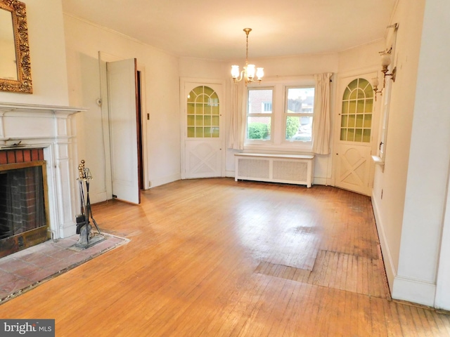 1216 23rd Ave, Altoona, PA 16601 - unfurnished living room featuring radiator, wood finished floors, a chandelier, a fireplace, and baseboards