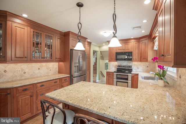 128 Cherry Ln, Doylestown, PA 18901 - kitchen with stainless steel appliances, a sink, a peninsula, brown cabinetry, and recessed lighting