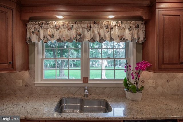 128 Cherry Ln, Doylestown, PA 18901 - kitchen view of a sink, brown cabinetry, backsplash, and light stone counters