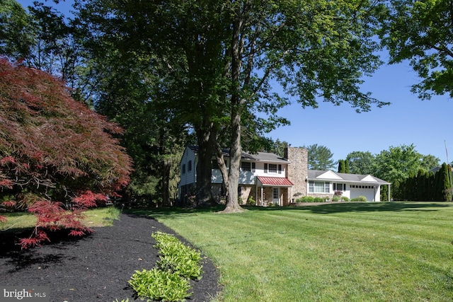 128 Cherry Ln, Doylestown, PA 18901 - view of front of house with a chimney, a front lawn, an attached garage, and metal roof