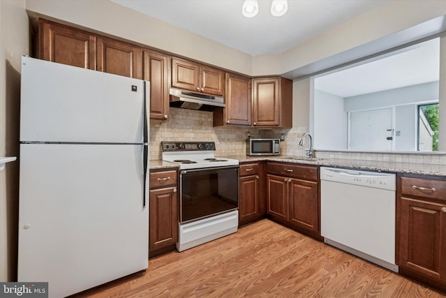 289 Summit House Unit 289, West Chester, PA 19382 - kitchen featuring white appliances, under cabinet range hood, a sink, decorative backsplash, and light wood finished floors