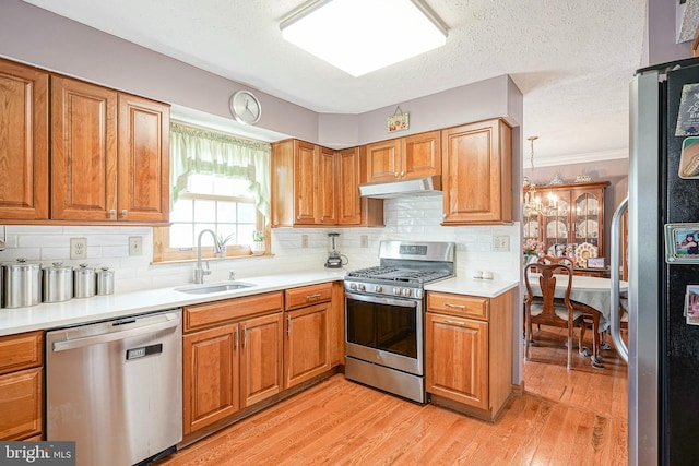 618 Walden Way, Lumberton, NJ 08048 - kitchen featuring stainless steel appliances, a sink, under cabinet range hood, brown cabinets, and light wood-type flooring