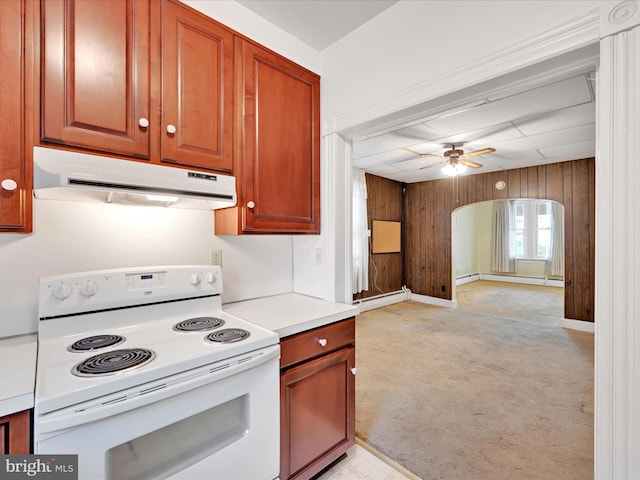 16 W Maple Ave, Myerstown, PA 17067 - kitchen with white range with electric stovetop, under cabinet range hood, ceiling fan, wooden walls, and light colored carpet