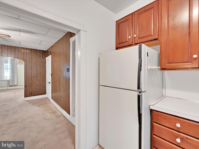 16 W Maple Ave, Myerstown, PA 17067 - kitchen with freestanding refrigerator, light carpet, wood walls, a baseboard heating unit, and light countertops