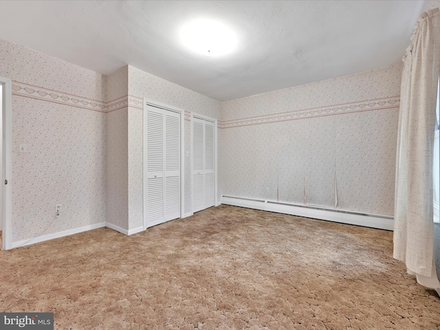 16 W Maple Ave, Myerstown, PA 17067 - unfurnished bedroom with a baseboard radiator, wallpapered walls, two closets, and carpet floors