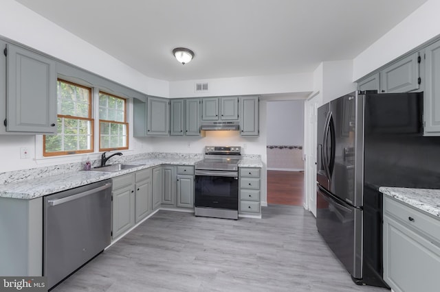 2 Stretch Dr, Mullica Hill, NJ 08062 - kitchen with appliances with stainless steel finishes, gray cabinetry, a sink, light wood-style floors, and under cabinet range hood