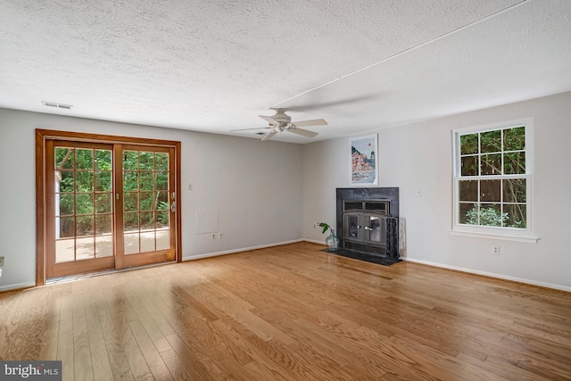9147 Everett Ct, Springfield, VA 22152 - unfurnished living room featuring a wood stove, a textured ceiling, wood finished floors, and a ceiling fan