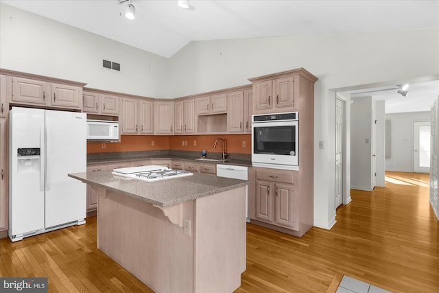 464 E Walnut St, Kutztown, PA 19530 - kitchen featuring white appliances, a sink, a kitchen island, light wood-style floors, and a kitchen bar