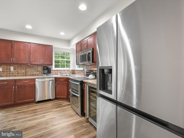 6290 Pinyon Pine Ct, Eldersburg, MD 21784 - kitchen with stainless steel appliances, light wood-type flooring, tasteful backsplash, light countertops, and wine cooler