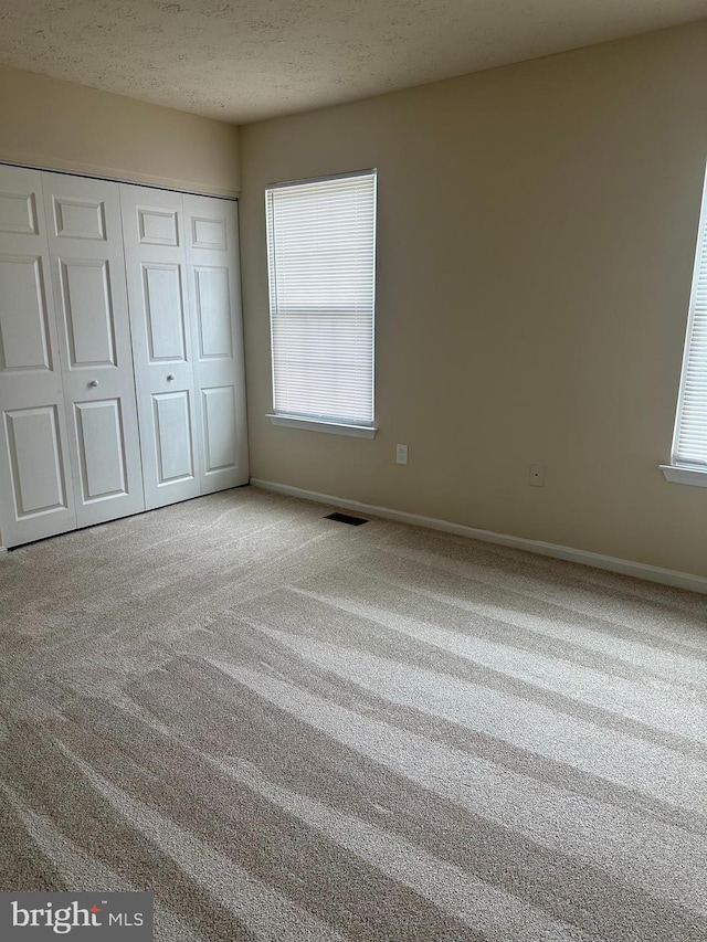 4321 Drake Ct, Waldorf, MD 20603 - unfurnished bedroom with carpet, a closet, a textured ceiling, and baseboards