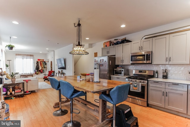 801 N 16th St Unit 1, Philadelphia, PA 19130 - kitchen featuring appliances with stainless steel finishes, gray cabinetry, backsplash, light wood-style floors, and light countertops