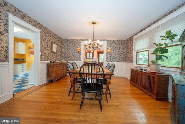 8317 High School Rd, Elkins Park, PA 19027 - dining area with wainscoting, a chandelier, wallpapered walls, and light wood-style flooring