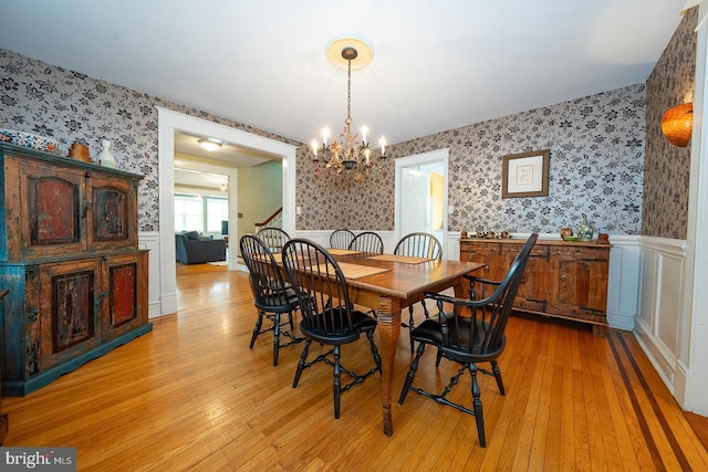 8317 High School Rd, Elkins Park, PA 19027 - dining room featuring wallpapered walls, a chandelier, wainscoting, light wood-style flooring, and a decorative wall