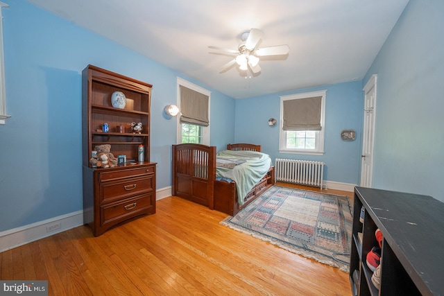 8317 High School Rd, Elkins Park, PA 19027 - bedroom with radiator heating unit, light wood-style flooring, multiple windows, and a ceiling fan
