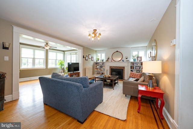8317 High School Rd, Elkins Park, PA 19027 - living area with light wood-style floors, a brick fireplace, and a chandelier