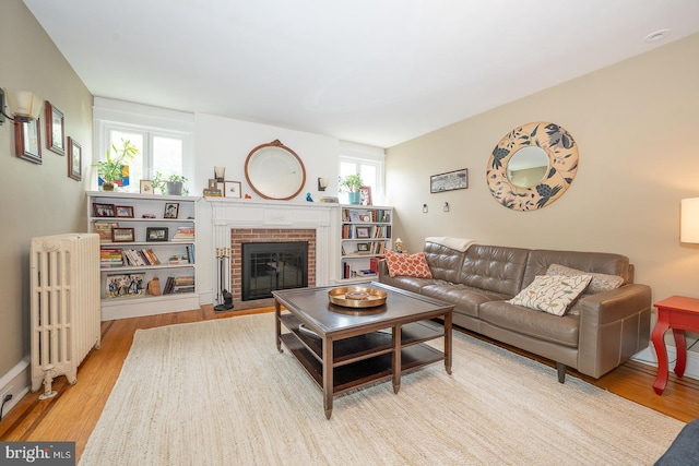 8317 High School Rd, Elkins Park, PA 19027 - living area with radiator heating unit, wood finished floors, and a brick fireplace
